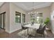 Elegant dining room with a marble table, chandelier, and large windows offering natural light at 5451 Prime Ter, North Port, FL 34286