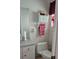 Clean bathroom with toilet, vanity, and wall-mounted shelf at 22580 Bolanos Ct, Port Charlotte, FL 33952