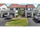 Exterior view of townhomes showcasing individual garages, landscaped yards, and upper-level balconies at 754 Avenida Estancia # 160, Venice, FL 34292