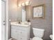 Stylish powder room with a white vanity and textured wallpaper at 116 Dolly St, Punta Gorda, FL 33950