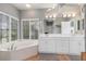Bathroom with double vanity, large soaking tub, and window at 116 Dolly St, Punta Gorda, FL 33950