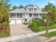 Two-story house with a metal roof, landscaping, and a brick driveway at 116 Dolly St, Punta Gorda, FL 33950