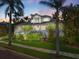 Two-story home with a spacious front yard, palm trees, and a brick driveway at 116 Dolly St, Punta Gorda, FL 33950