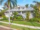 Two-story house with a metal roof, landscaping, and a brick driveway at 116 Dolly St, Punta Gorda, FL 33950