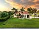 Luxury estate with palm trees, beautiful lawn, and sunset views at 24087 Santa Inez Rd, Punta Gorda, FL 33955