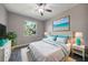 Bright bedroom with plush white bedding, light walls, dark wood floors, and a large window offering ample light at 4767 Maurbach Ter, North Port, FL 34286