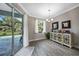 Dining area with sliding glass doors offering views of the pool, complemented by a stylish accent cabinet at 4767 Maurbach Ter, North Port, FL 34286