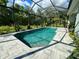 Enclosed rectangular pool with gray tile deck and tropical landscaping at 4767 Maurbach Ter, North Port, FL 34286