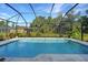 Enclosed rectangular swimming pool with light gray tile deck at 4767 Maurbach Ter, North Port, FL 34286