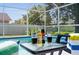 Relaxing poolside scene featuring refreshing drinks and a serene view of the screened-in swimming pool at 635 Erroll St, Port Charlotte, FL 33952