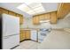 Galley kitchen with light wood cabinets and white appliances at 1515 Forrest Nelson Blvd # G102, Port Charlotte, FL 33952