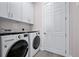 Bright laundry room with washer, dryer, and ample cabinet space at 3712 Carmichael Dr, Punta Gorda, FL 33950