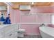 Modern bathroom with pink walls, white vanity, and a free-standing tub at 1507 Lavilla Rd, Punta Gorda, FL 33950
