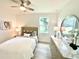 Cozy bedroom with a dresser, lamps, ceiling fan and decorative artwork above the bed at 3140 Sweet Gum Dr, Punta Gorda, FL 33982
