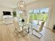 Bright dining area with modern chandelier, large glass table and light colored wood flooring at 3140 Sweet Gum Dr, Punta Gorda, FL 33982