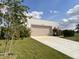 Contemporary home featuring a large two car garage and a well-manicured lawn at 3140 Sweet Gum Dr, Punta Gorda, FL 33982