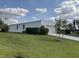Wide view of house showing architectural style, lawn, and landscaping at 3140 Sweet Gum Dr, Punta Gorda, FL 33982