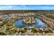 Beautiful aerial view of a residential waterfront community highlighting homes surrounding a lake, with ocean background at 24723 Rio Villa Lakes Cir, Punta Gorda, FL 33950