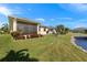 Spacious backyard featuring a screened-in porch, lush lawn, meticulous landscaping and serene water views at 24723 Rio Villa Lakes Cir, Punta Gorda, FL 33950
