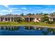 Backyard featuring a well-maintained lawn, peaceful lake views, and a screened-in lanai at 24723 Rio Villa Lakes Cir, Punta Gorda, FL 33950