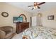 Cozy bedroom with floral bedding, TV, antique dresser, and view of lake at 24723 Rio Villa Lakes Cir, Punta Gorda, FL 33950