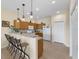 Open-concept kitchen featuring bar seating, wood cabinets, and white appliances at 24723 Rio Villa Lakes Cir, Punta Gorda, FL 33950