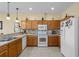 Bright kitchen with tile flooring, wood cabinets, and modern white appliances at 24723 Rio Villa Lakes Cir, Punta Gorda, FL 33950