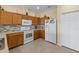 Well-lit kitchen with wood cabinets, modern appliances, mosaic backsplash, and tile flooring at 24723 Rio Villa Lakes Cir, Punta Gorda, FL 33950