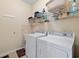 Laundry room with white washer and dryer and shelving at 24723 Rio Villa Lakes Cir, Punta Gorda, FL 33950