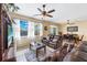 Bright living room with plush seating, a ceiling fan, and sliding glass doors at 24723 Rio Villa Lakes Cir, Punta Gorda, FL 33950