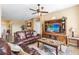 Comfortable living room featuring a large sofa, entertainment center, and neutral decor at 24723 Rio Villa Lakes Cir, Punta Gorda, FL 33950