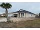 New construction home showcasing a tan exterior, attached garage, and a palm tree at 4250 Oak Terrace Cir, Port Charlotte, FL 33953