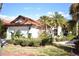 Home exterior showcases a red-tiled roof, palm trees, lush landscaping, and a clean white exterior at 956 Harbor Town Dr, Venice, FL 34292