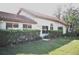 Charming home featuring a red tile roof, manicured hedges, and lush landscaping at 956 Harbor Town Dr, Venice, FL 34292