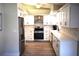 Bright kitchen featuring white cabinets, stainless steel appliances, and wood-look flooring at 956 Harbor Town Dr, Venice, FL 34292