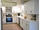 Elegant kitchen with stainless steel appliances, white cabinetry, modern fixtures, and light countertops at 956 Harbor Town Dr, Venice, FL 34292