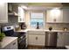 Bright kitchen boasts stainless steel appliances, white cabinets, a farmhouse sink, and stylish countertops at 956 Harbor Town Dr, Venice, FL 34292