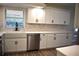 Modern kitchen with white shaker cabinets, a farmhouse sink, and quartz countertops at 956 Harbor Town Dr, Venice, FL 34292