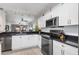 Modern kitchen with white cabinets, stainless steel appliances, and granite countertops at 175 Kings Hwy # 718, Punta Gorda, FL 33983