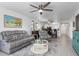Spacious living room with gray couches and a view into the dining area and kitchen at 175 Kings Hwy # 718, Punta Gorda, FL 33983