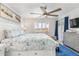 Main bedroom with a king-size bed, ceiling fan, and window shutters at 175 Kings Hwy # 718, Punta Gorda, FL 33983