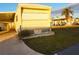 Yellow mobile home with ramp and landscaped lawn at 5524 Holiday Park Blvd, North Port, FL 34287