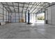 Large garage with a car lift and open door at 17152 Wintergarden Ave, Port Charlotte, FL 33948