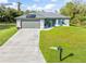 Single-story home with gray garage door and solar panels, driveway, and grassy yard at 4340 Adolph Ave, North Port, FL 34288