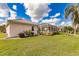 Landscaped backyard with grassy lawn and screened pool area at 2970 Royal Palm Dr, North Port, FL 34288