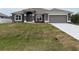 Gray house with a white garage door and a neatly landscaped lawn at 10225 Winnipeg St, Port Charlotte, FL 33981