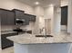 Modern kitchen featuring dark cabinetry, granite countertops, and stainless steel appliances at 10225 Winnipeg St, Port Charlotte, FL 33981