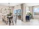 Elegant dining room with large windows that offer scenic backyard water views, pendant lighting, and modern decor at 9572 Turtle Grass Cir, Punta Gorda, FL 33950