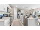Modern kitchen featuring stainless steel appliances, white cabinets, and a stylish island with quartz countertop at 9572 Turtle Grass Cir, Punta Gorda, FL 33950