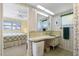 Bathroom featuring floral wallpaper, mirrored vanity, and an open door to the primary bedroom at 2501 Rio Largo Ct, Punta Gorda, FL 33950